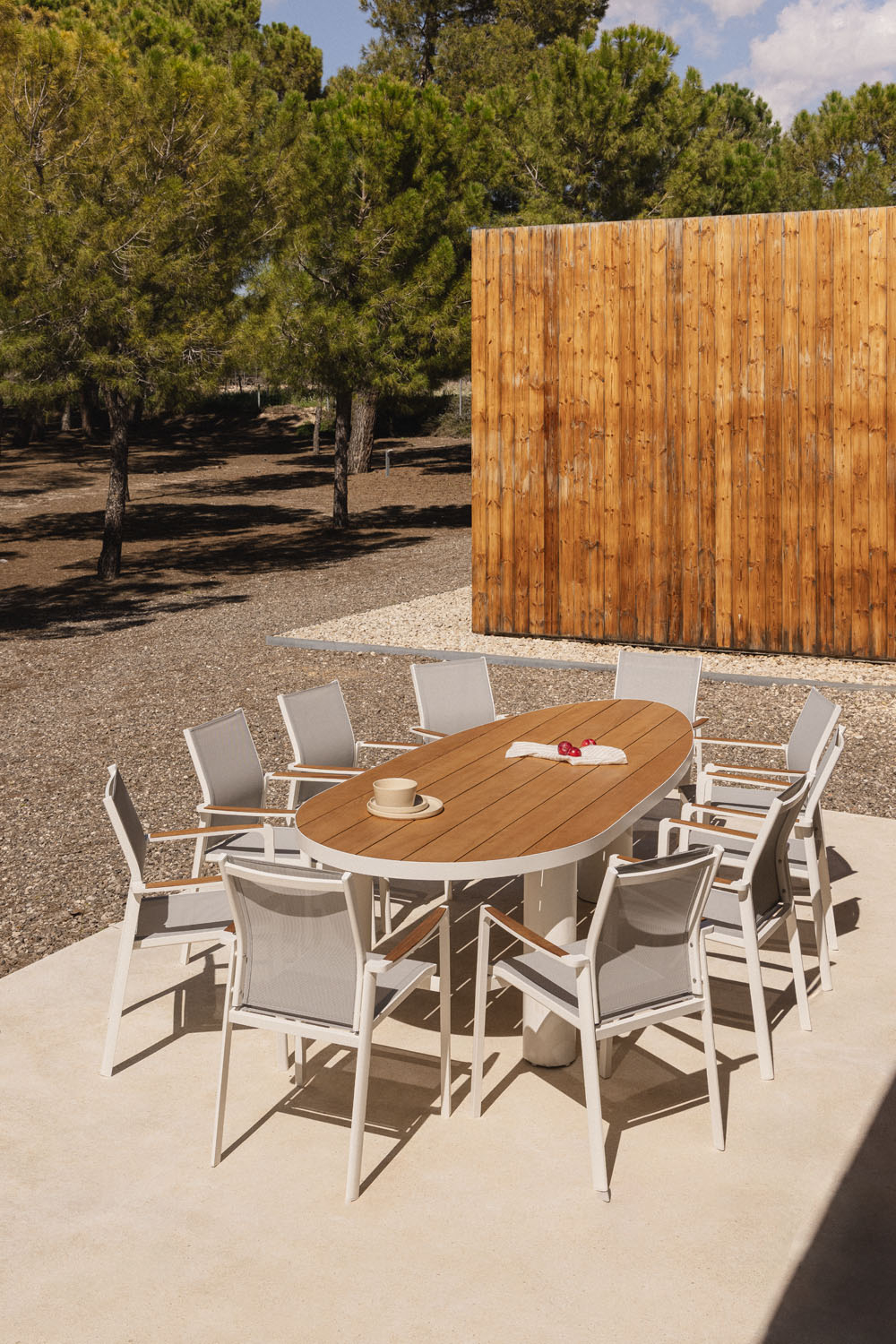 Set da tavolo ovale Taneli 260x110 cm in alluminio e legno di teak e 10 sedie da giardino impilabili Elvira in alluminio.