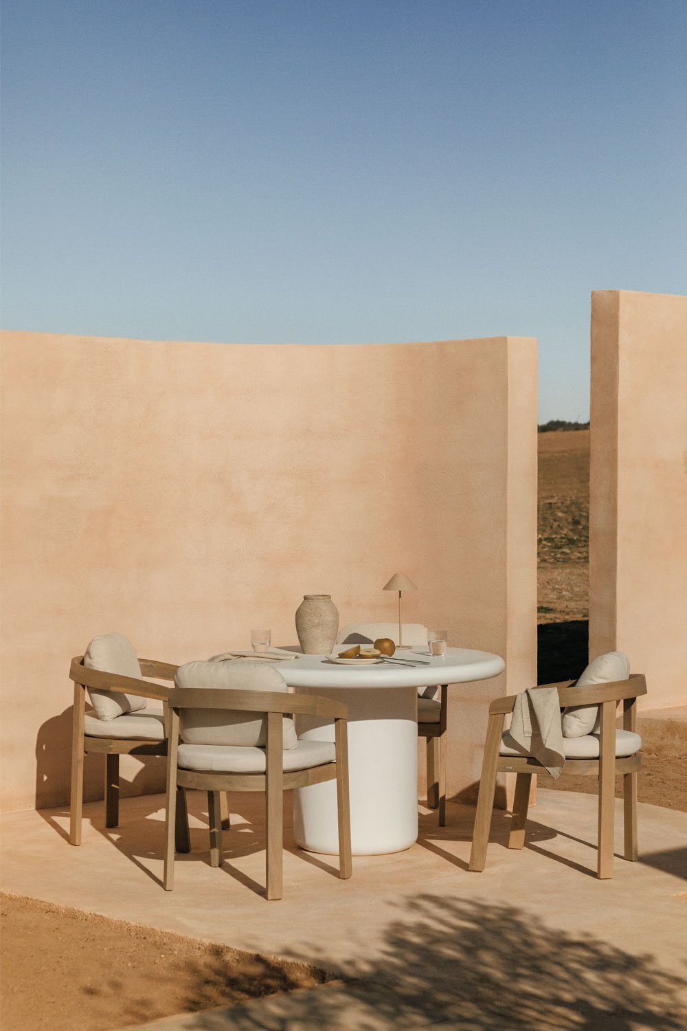 Set tavolo rotondo Ø120 cm in cemento Namara e 4 sedie da giardino con braccioli in legno di acacia Uleno